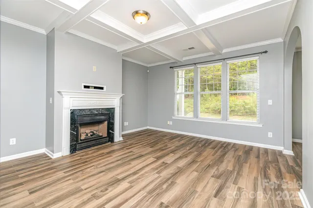 a view of empty room with wooden floor and fireplace