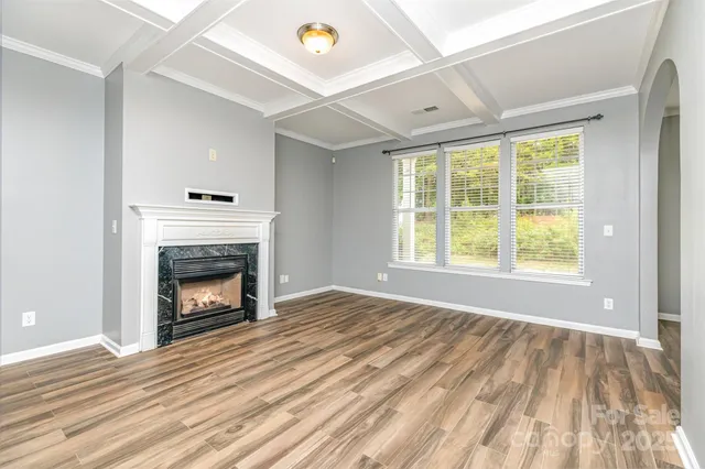 a view of empty room with wooden floor and fireplace