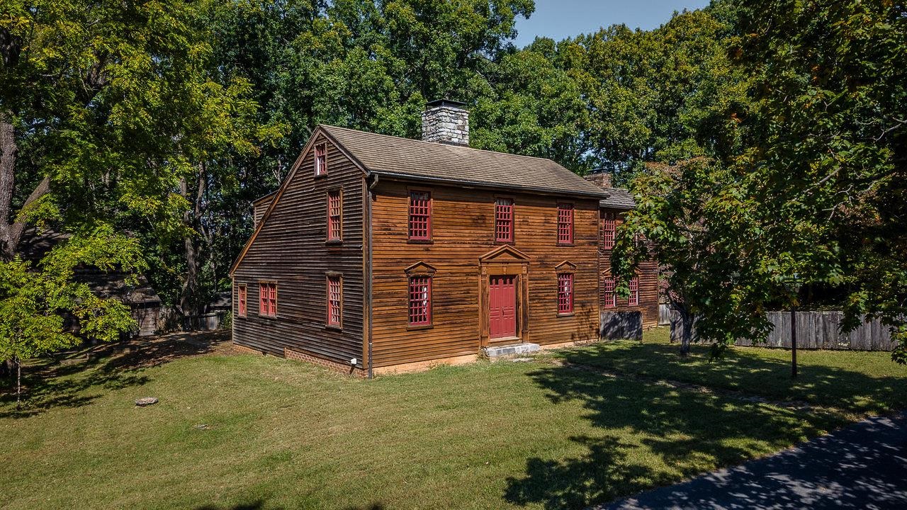 a view of a house with a small yard and large tree
