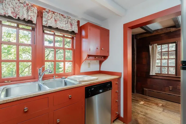 an empty room with wooden floor and a fireplace