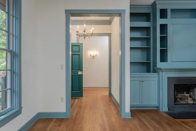 a view of a hallway with wooden floor and a fireplace