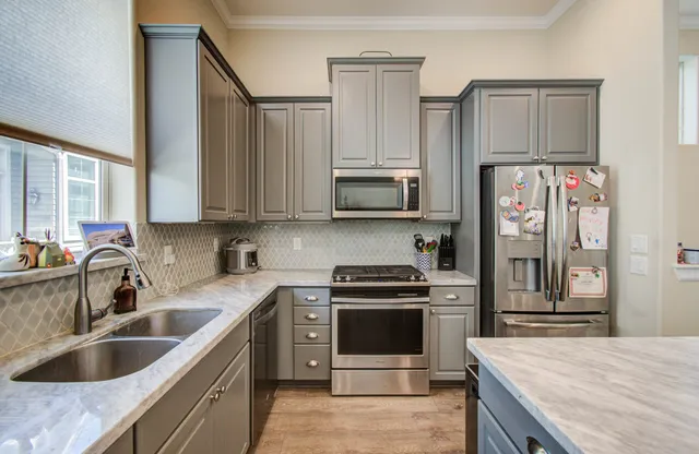 a kitchen with stainless steel appliances granite countertop a sink stove and refrigerator