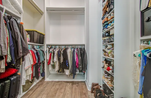 a view of walk in closet with clothes