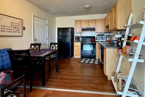 a kitchen with stainless steel appliances wooden floor dining table and chairs