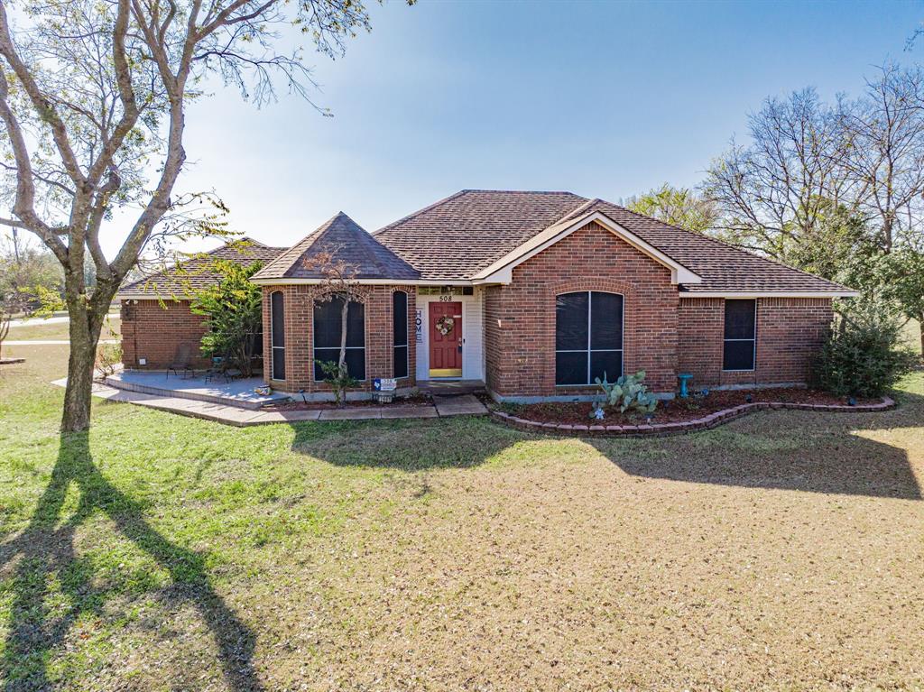 Ranch-style house with brick siding, a shingled roof, and a front lawn