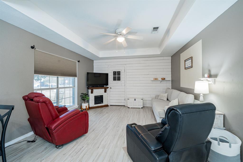 508 Tishomingo Road Waxahachie, TX 75165 - Photo 14 of 26 a living room with furniture a flat screen tv and a fireplace