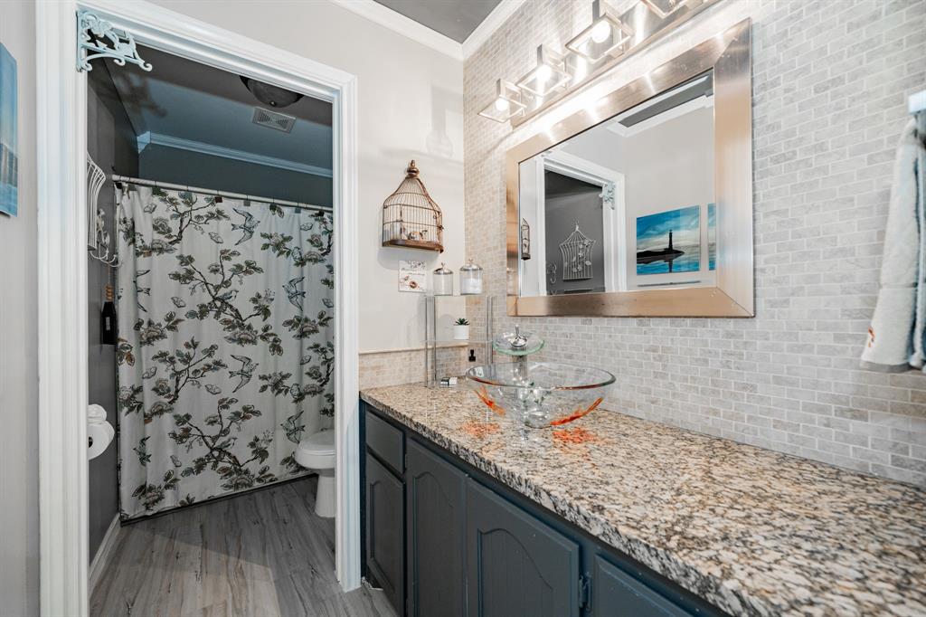 508 Tishomingo Road Waxahachie, TX 75165 - Photo 21 of 26 a bathroom with a granite countertop sink a mirror and shower