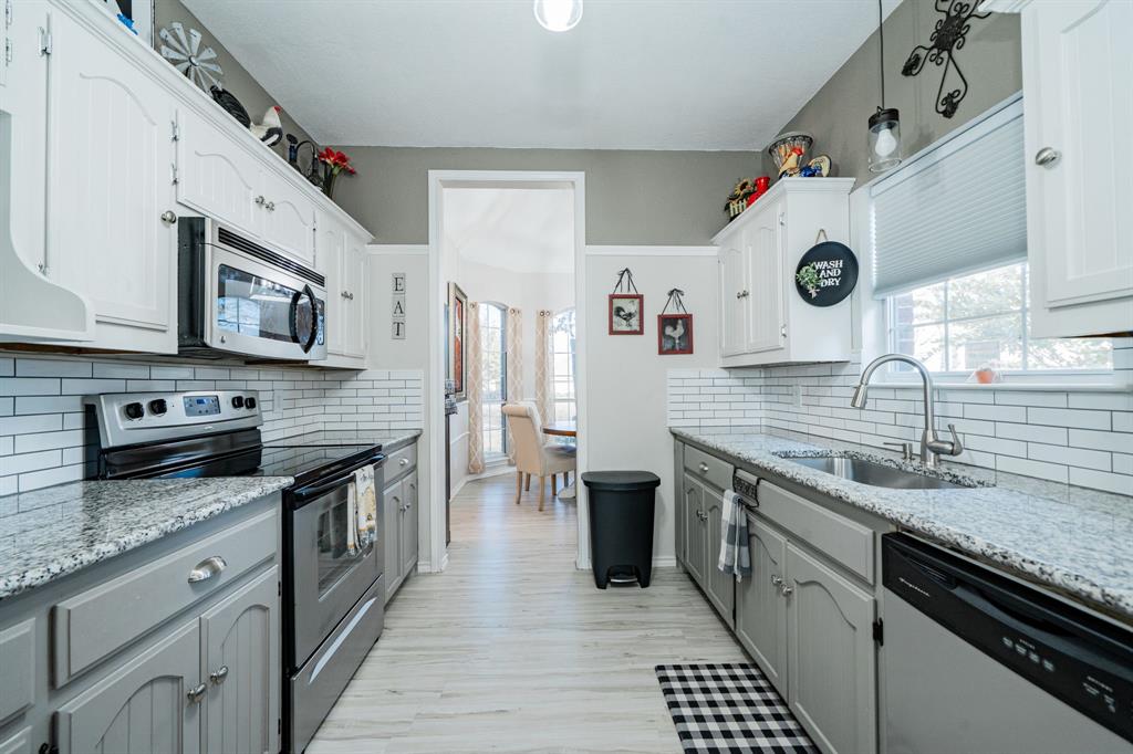 508 Tishomingo Road Waxahachie, TX 75165 - Photo 9 of 26 a kitchen with stainless steel appliances granite countertop a stove and a sink