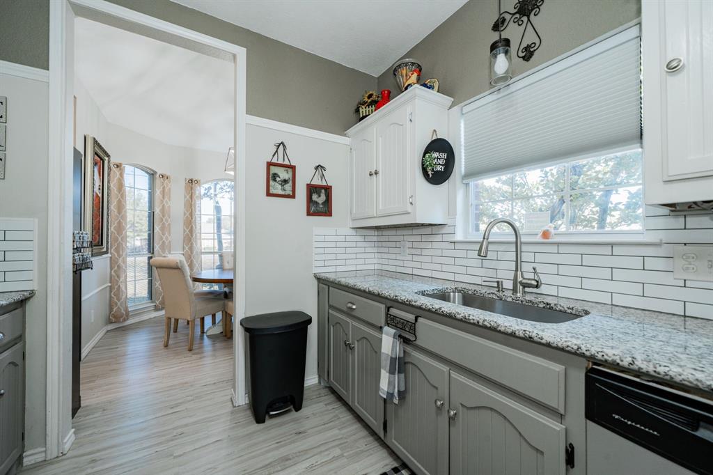 508 Tishomingo Road Waxahachie, TX 75165 - Photo 10 of 26 a kitchen with a sink cabinets and wooden floor