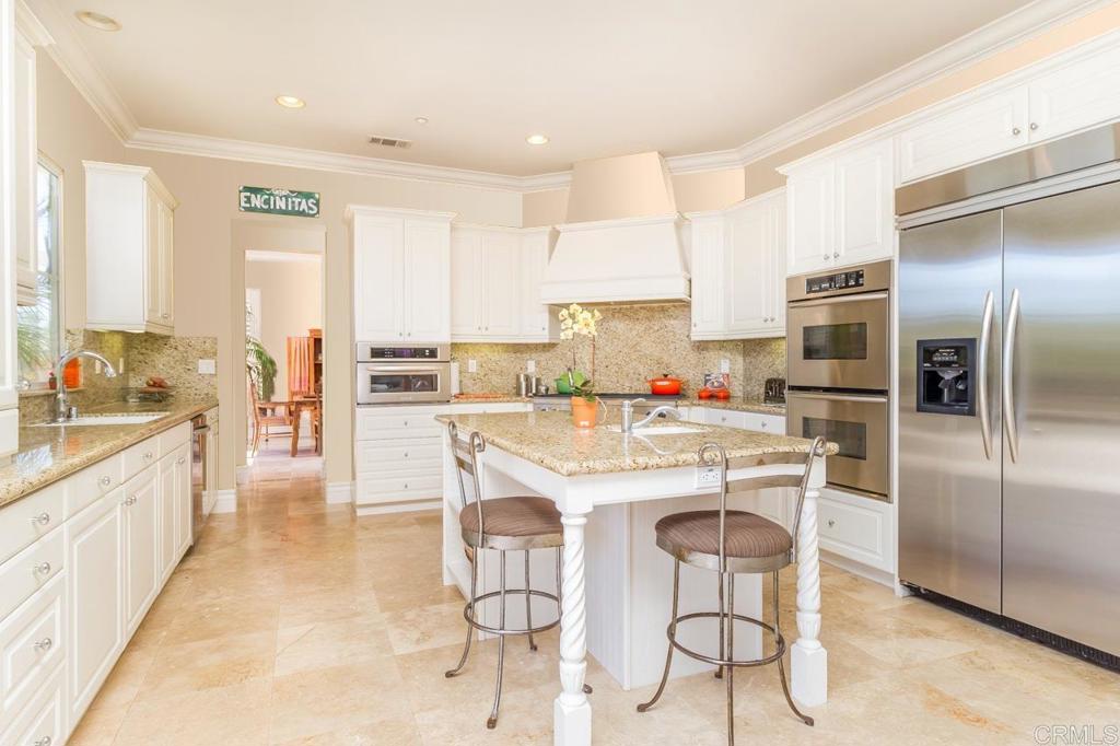 1499 Paseo De Las Flores Encinitas, CA 92024 - Photo 13 of 30 a kitchen with kitchen island a counter top space cabinets and stainless steel appliances