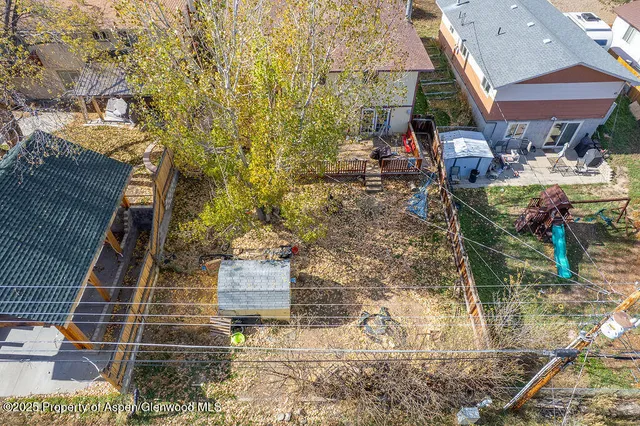 a aerial view of a house with table and chairs under an umbrella