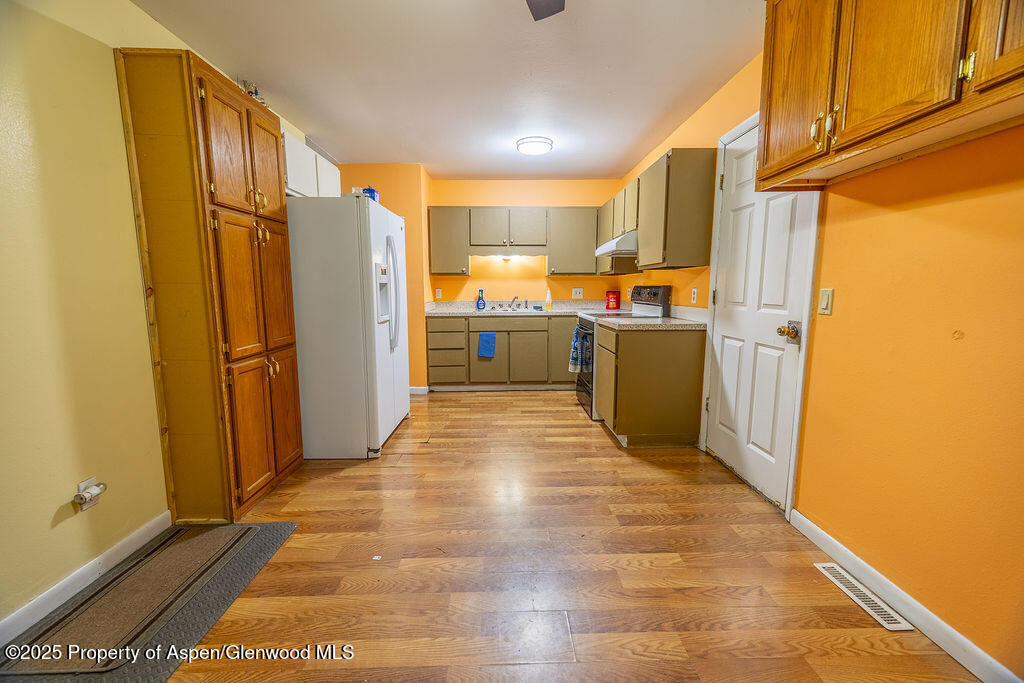 1159 Barclay Street Craig, CO 81625 - Photo 7 of 45 a kitchen with a refrigerator and a stove