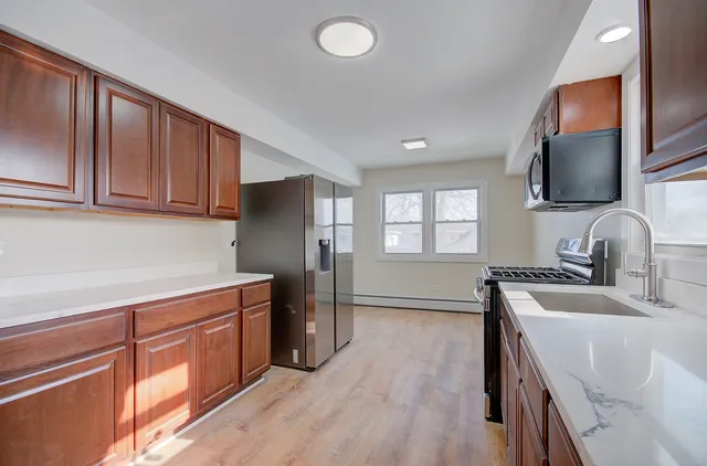a kitchen with stainless steel appliances granite countertop a sink stove and refrigerator