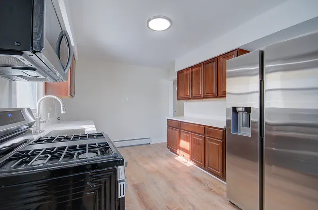 a kitchen with stainless steel appliances granite countertop a stove and a refrigerator
