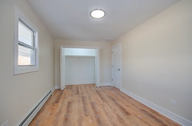 a view of a room with wooden floor and fan