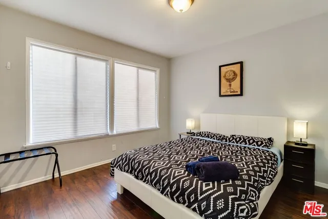 a bedroom with bed and wooden floor