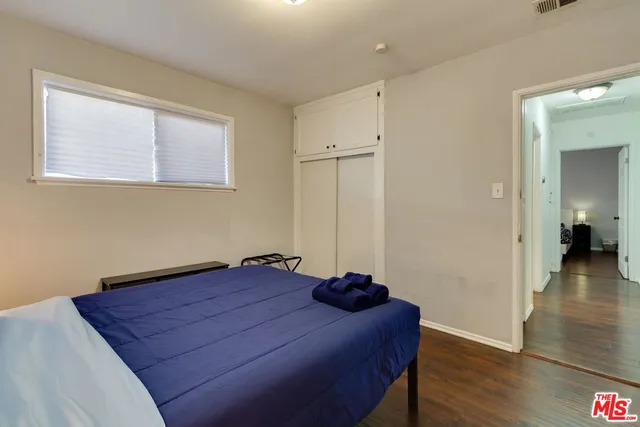 a room with a bed and wooden floor