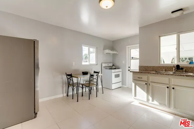 a large white kitchen with cabinets and a refrigerator