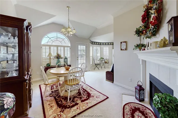 a living room with furniture a chandelier and a fireplace