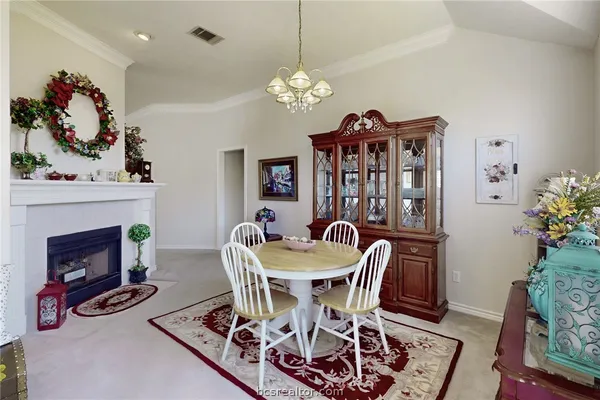 a view of a dining room with furniture and chandelier