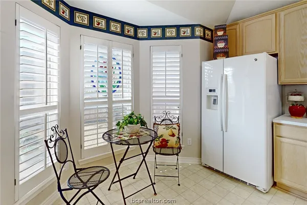 a white refrigerator freezer sitting in a kitchen next to a window