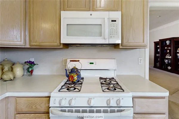 a kitchen with white cabinets and appliances