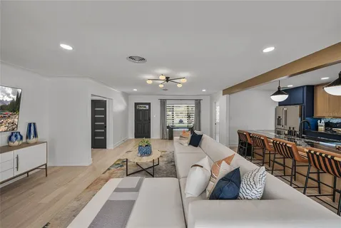 a dining table chairs and a chandelier fan in a kitchen