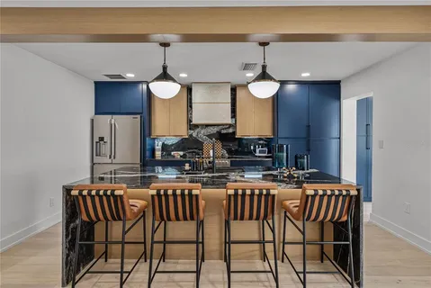 a kitchen with granite countertop a sink stove and cabinets