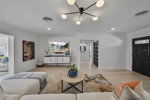 a living room with furniture kitchen view and a window