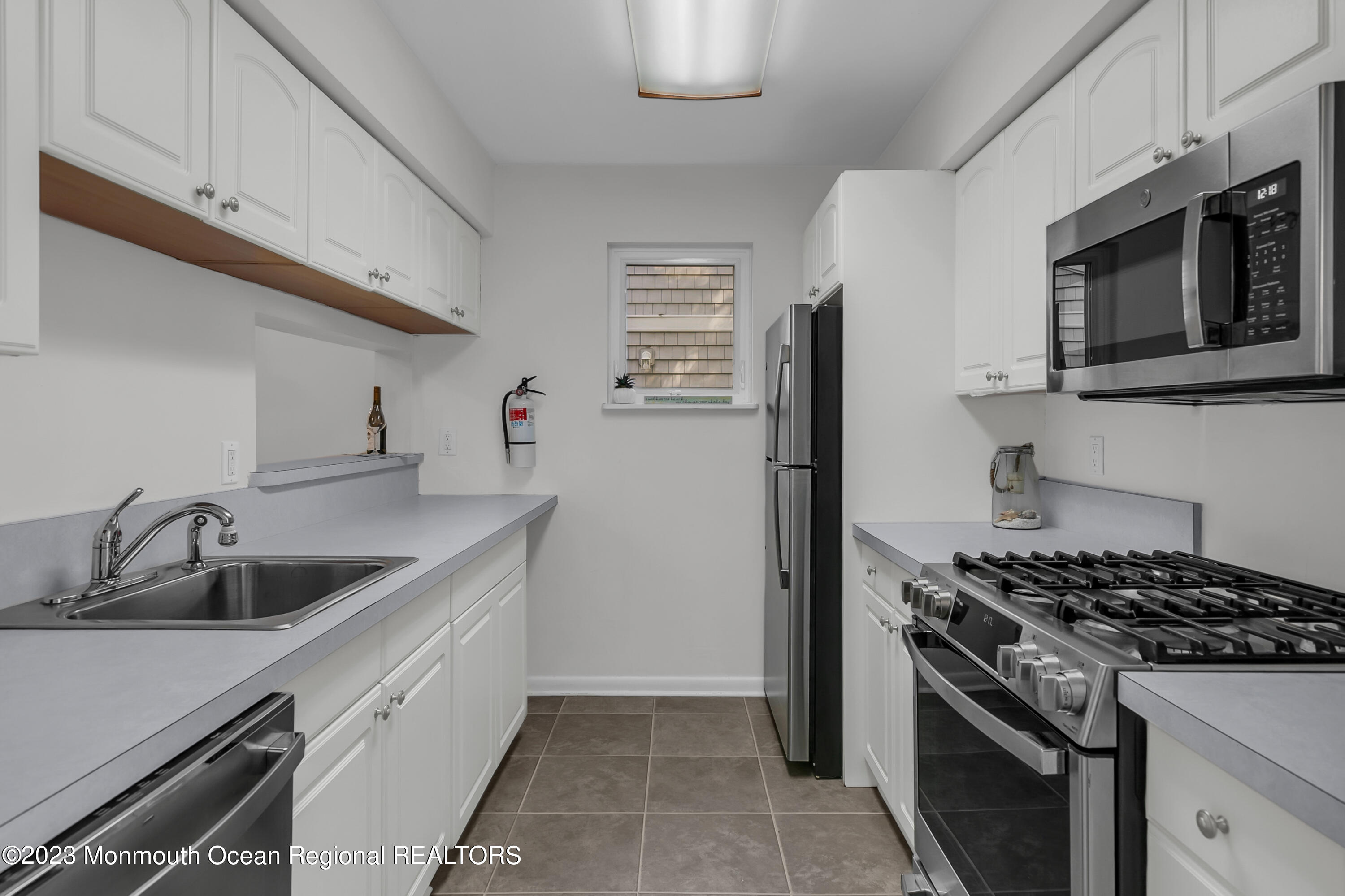 49 Locust Way Spring Lake Heights, NJ 07762 - Photo 8 of 34 a kitchen with stainless steel appliances granite countertop a sink stove and microwave