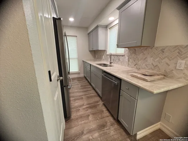 a kitchen with a sink a refrigerator a window and cabinets