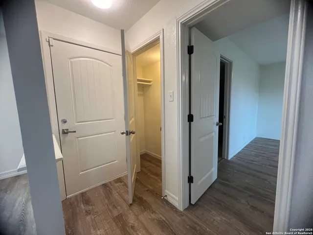 a view of a hallway with wooden floor and closet area