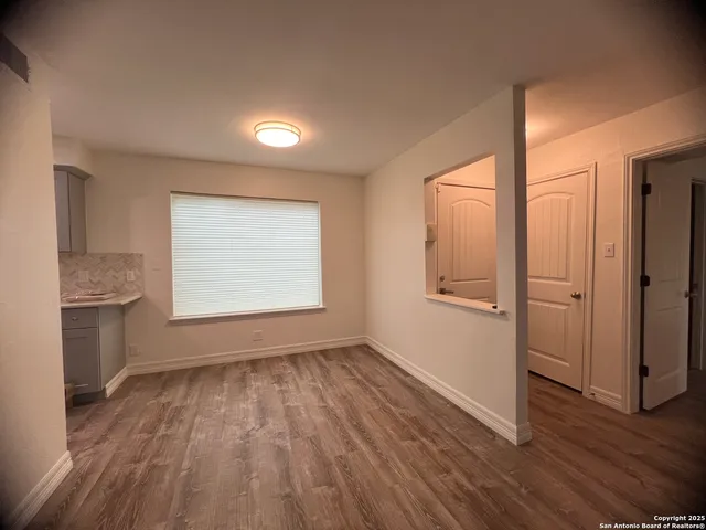 an empty room with wooden floor and a window