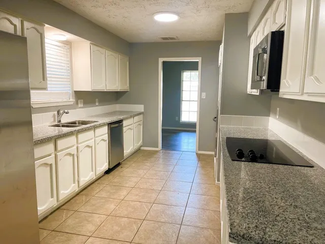 a kitchen with a sink a stove and cabinets