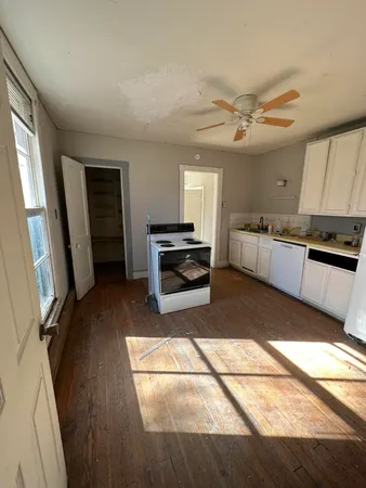 a kitchen with granite countertop a refrigerator a sink a stove and cabinets
