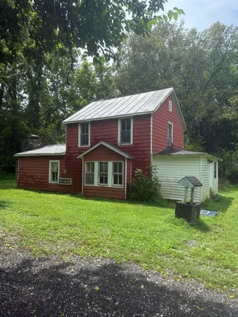 a view of a yard in front of a house with large trees