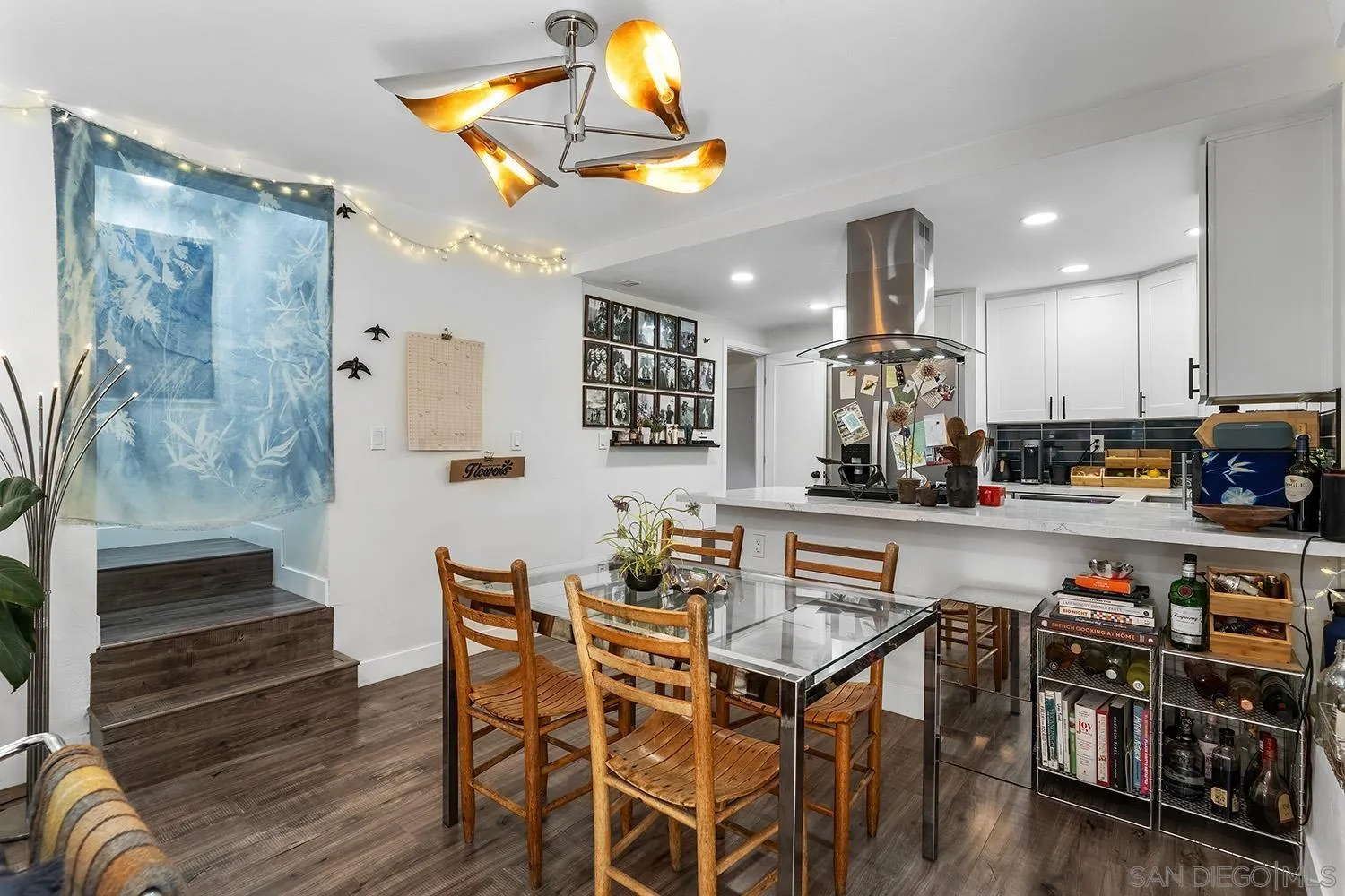 3109 Hawk Street San Diego, CA 92103 - Photo 62 of 75 a kitchen with stainless steel appliances granite countertop a stove top oven a sink a dining table and chairs with wooden floor