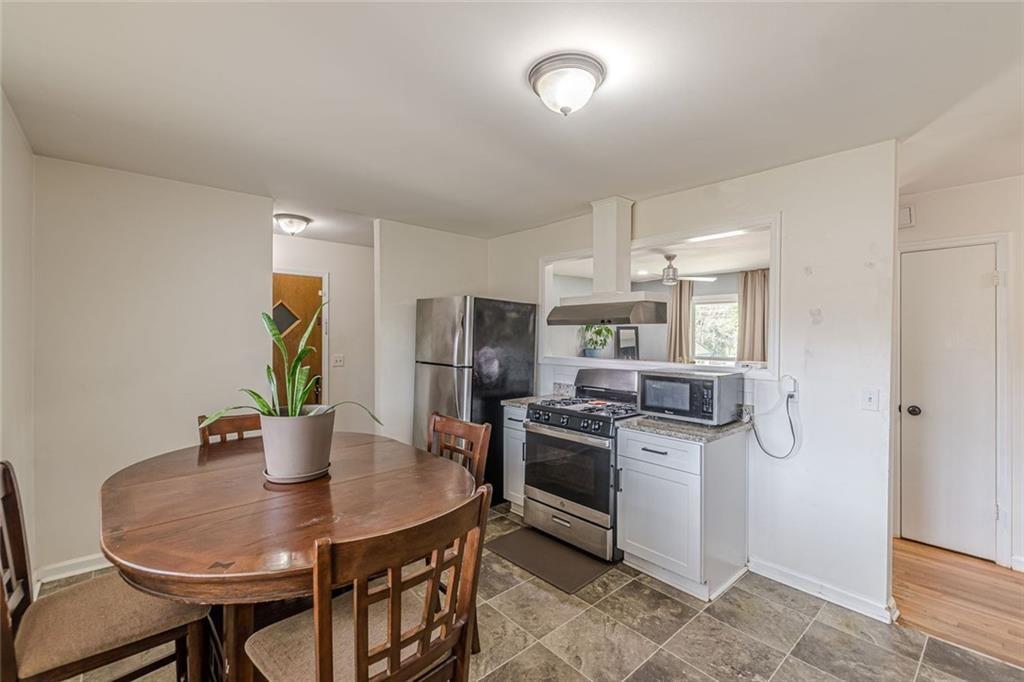 4558 Ryan Road Conley, GA 30288 - Photo 11 of 34 a kitchen with stainless steel appliances a dining table and chairs