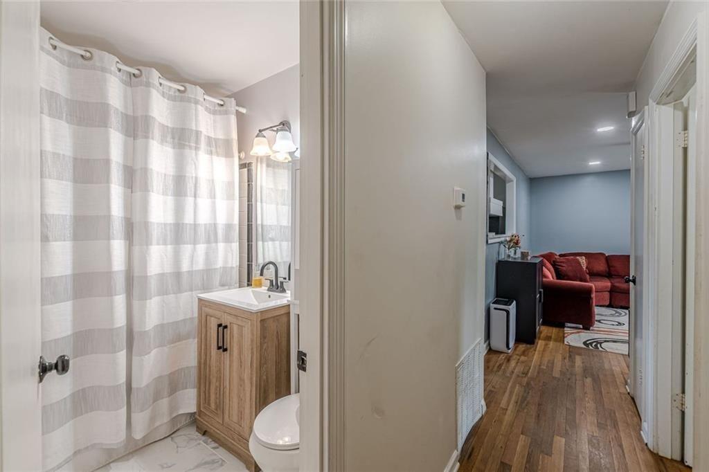 4558 Ryan Road Conley, GA 30288 - Photo 21 of 34 a en suite bathroom with a sink a mirror a window and a shower