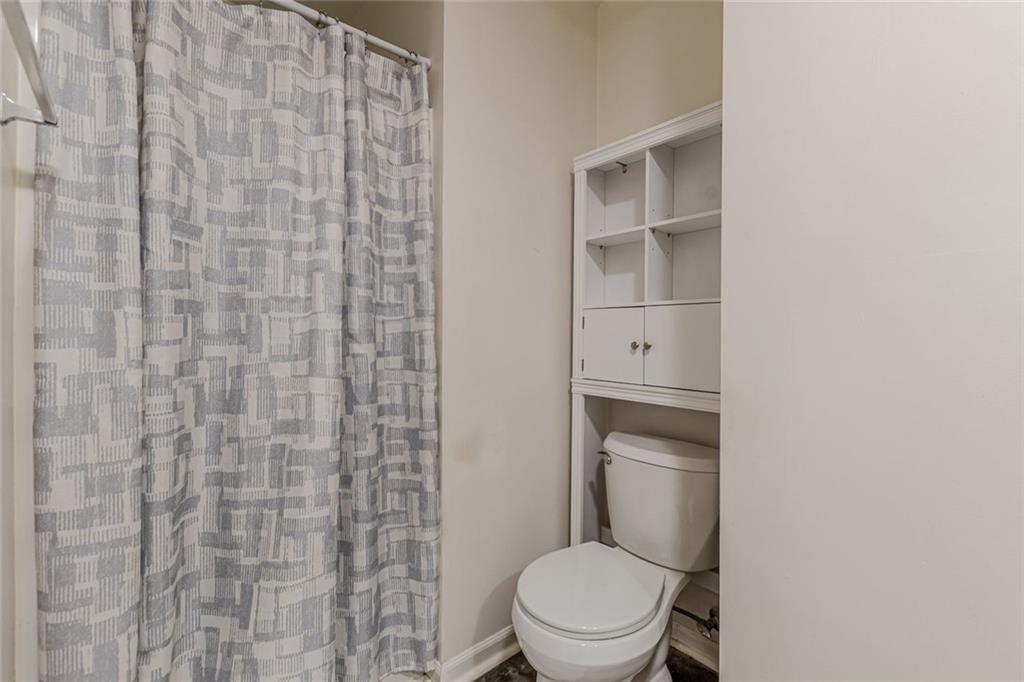 4558 Ryan Road Conley, GA 30288 - Photo 30 of 34 a white toilet sitting next to a shower curtain
