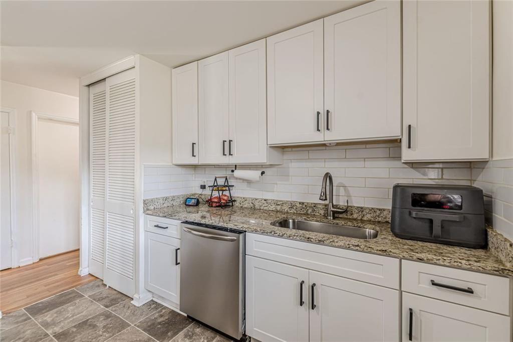 4558 Ryan Road Conley, GA 30288 - Photo 9 of 34 a kitchen with granite countertop white cabinets and white appliances