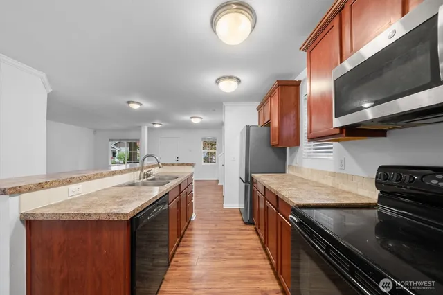 a kitchen with stainless steel appliances granite countertop a sink stove and cabinets