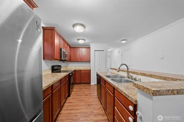a kitchen with stainless steel appliances granite countertop a stove a sink and a microwave