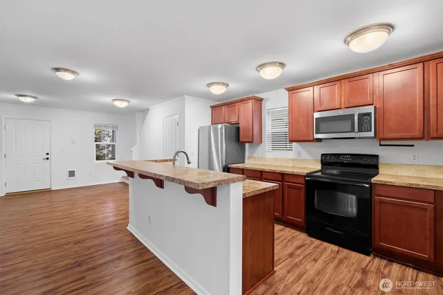 a kitchen with stainless steel appliances granite countertop a sink stove and cabinets