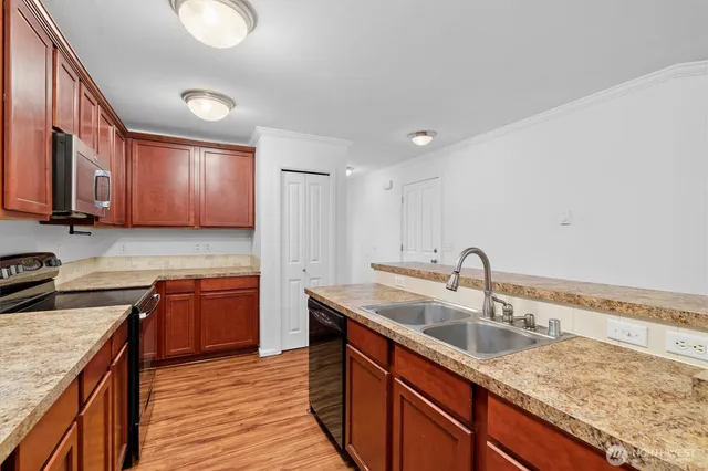 a kitchen with stainless steel appliances granite countertop a refrigerator a stove and a sink