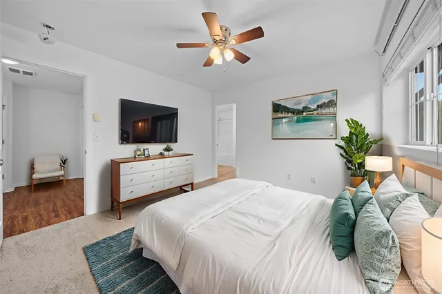 an empty room with windows and fan