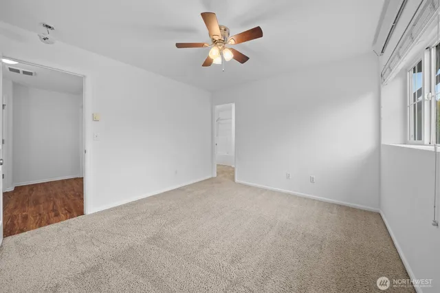 an empty room with closet and ceiling fan
