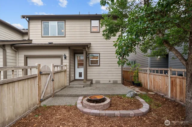 a view of a house with a small yard and a wooden deck