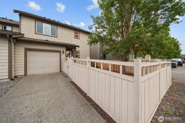 a view of a backyard with wooden fence