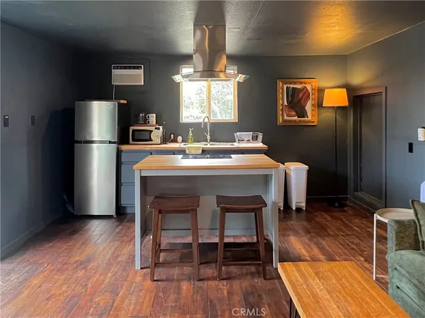 a kitchen with a table chairs refrigerator and microwave